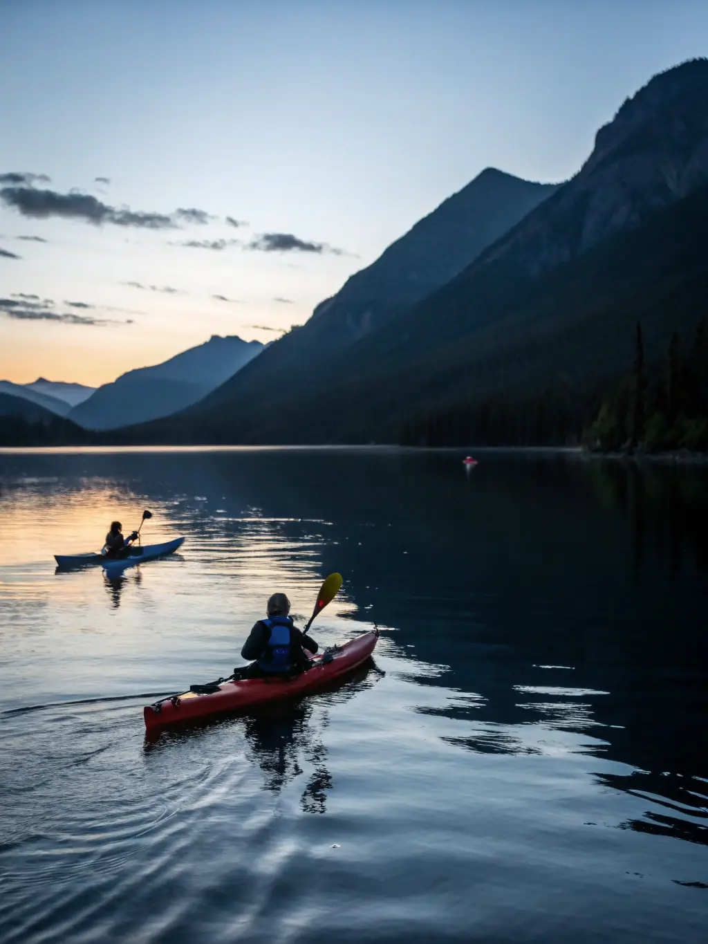 A serene image of kayakers paddling on a calm lake, surrounded by mountains and forests, reflecting the tranquility and beauty of the natural environment.